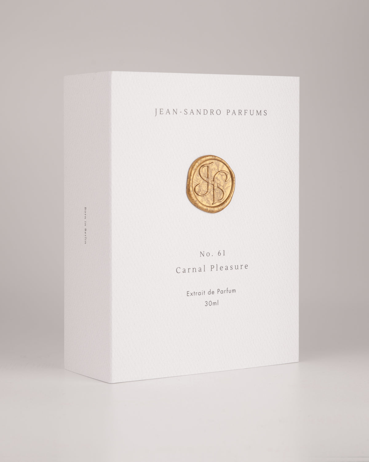 A white rectangular box for Jean-Sandro Parfums, specifically No. 61 Carnal Pleasure, with a gold circular logo in the center, photographed on a light gray background.