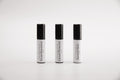 Three small cylindrical cosmetic tubes with black caps and white bodies, arranged side by side on a light gray background. The labels read 'Intocandescence', 'Carnal Pleasure', and 'Second Skin'.